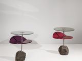 deux tables d'appoint avec un plateau en verre et un caillou posé sur une surface blanche