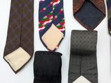 a lot of ties that are on a white table