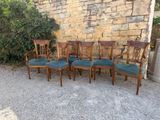 six chairs sitting next to each other in front of a stone wall
