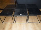 three black tables sitting on top of a wooden floor next to each other