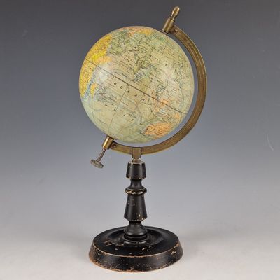 un vieux globe terrestre posé sur un socle, avec une clé à l'intérieur