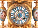a gold clock with blue and white decorations on it
