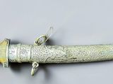 a silver and gold horn shaped object on a white surface
