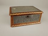 une vieille boîte en bois posée sur une surface blanche
