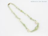 collier composé de perles vertes et blanches sur fond blanc