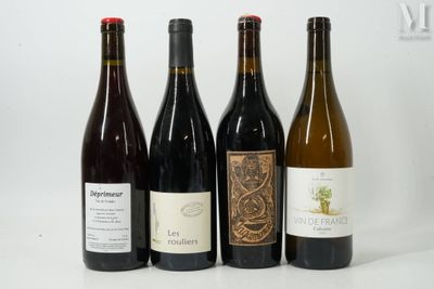 quatre bouteilles de vin sont alignées sur une surface blanche