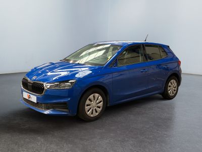 une voiture bleue garée dans une pièce aux murs blancs