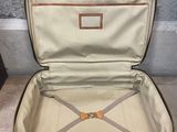 a brown suitcase with a handle and a pair of shoes in it