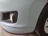 a close up of a car ' s front bumper with a red tail light