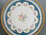 a blue and white plate with gold trim and flowers on it