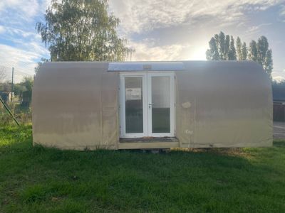 une photo d'une petite maison au milieu d'un champ
