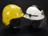 two safety helmets are sitting next to each other on a black surface