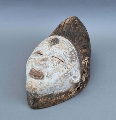 gros plan d'un masque en bois sur une surface grise