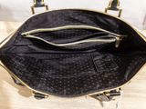 the inside of a black and gold handbag on a wooden table