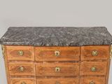 a marble top chest of drawers with brass handles