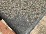 a black granite table top on a red and white tiled floor