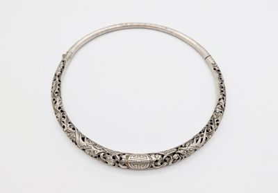 a close up of a silver bracelet on a white surface