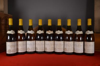 several bottles of wine are lined up on a red table