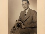 portrait d'un homme en costume avec un chien sur les genoux