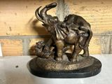 une statue représentant un éléphant avec un éléphanteau sur le dos