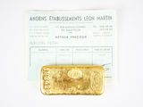 a gold bar sitting on top of a piece of paper