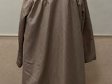 an image of a coat on a mannequin stand in front of a wall
