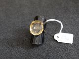 une bague noire sertie d'une pierre jaune, avec une étiquette de prix