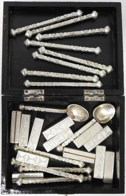 an assortment of silver spoons and spoon rest in a black box