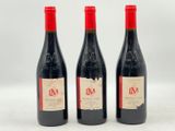 trois bouteilles de vin rouge posées l'une à côté de l'autre sur une surface blanche