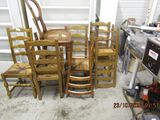 several chairs and a table in a room with a stove in the background