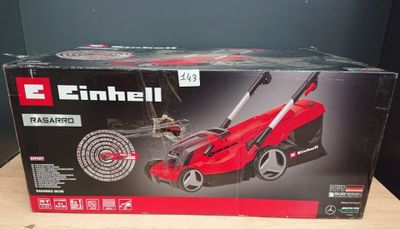 the box of a red lawn mower sits on a wooden table
