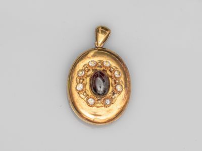 un gros plan d'un pendentif en or orné d'une pierre violette