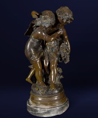une statue en bronze représentant un garçon et une fille sur un socle