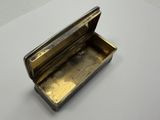a close up of a small metal box on a white surface