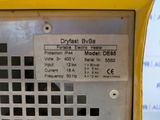 a close up of a yellow pay phone with a black and white checkered label