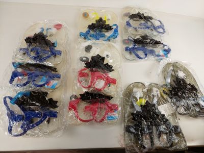 de nombreux jouets en plastique de toutes sortes, rangés dans des sacs posés sur une table