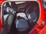 the back seats of a red car with the door open