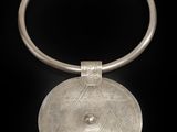 un gros plan d'un collier en argent sur fond noir