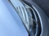 a close up of a car ' s headlight on a parking lot