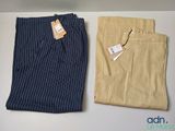 deux pantalons pour homme, avec une étiquette, posés sur une table