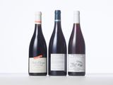 three bottles of wine are lined up on a table
