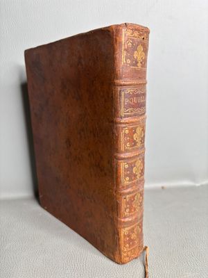 an old book sitting on top of a table next to a white wall