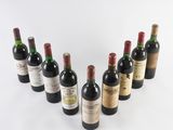 six bottles of wine lined up in a row on a white surface