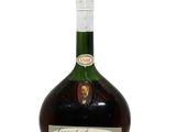 une photo d'une bouteille de brandy posée sur une table