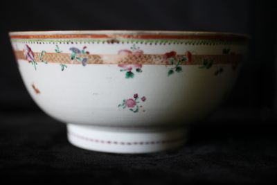 un bol blanc orné de fleurs, posé sur une table