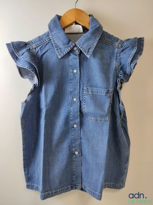 un gros plan d'une chemise suspendue à un cintre accroché au mur