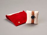 a red and white pillow with a watch on it