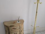 un coin d'une pièce avec une table et un porte-manteau