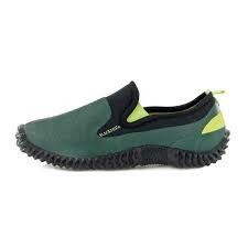 une chaussure verte et noire avec des semelles noires sur fond blanc