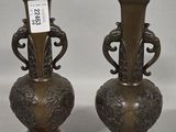 pair of antique bronze vases with ornate designs on each of them